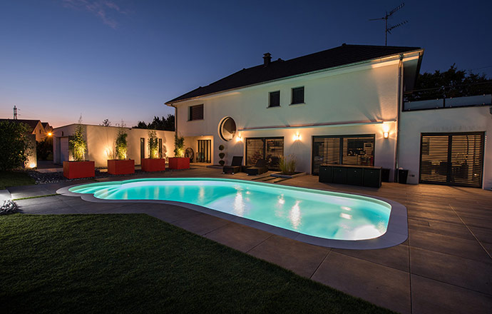 Piscine de nuit, dans un jardin élégant